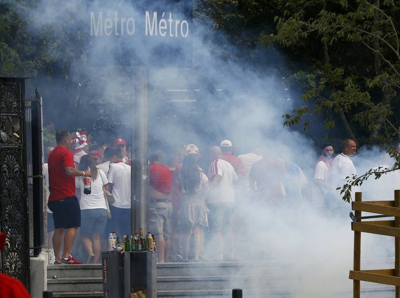 I tifosi polacchi scappano dopo il lancio di lacrimogeni. Reuters